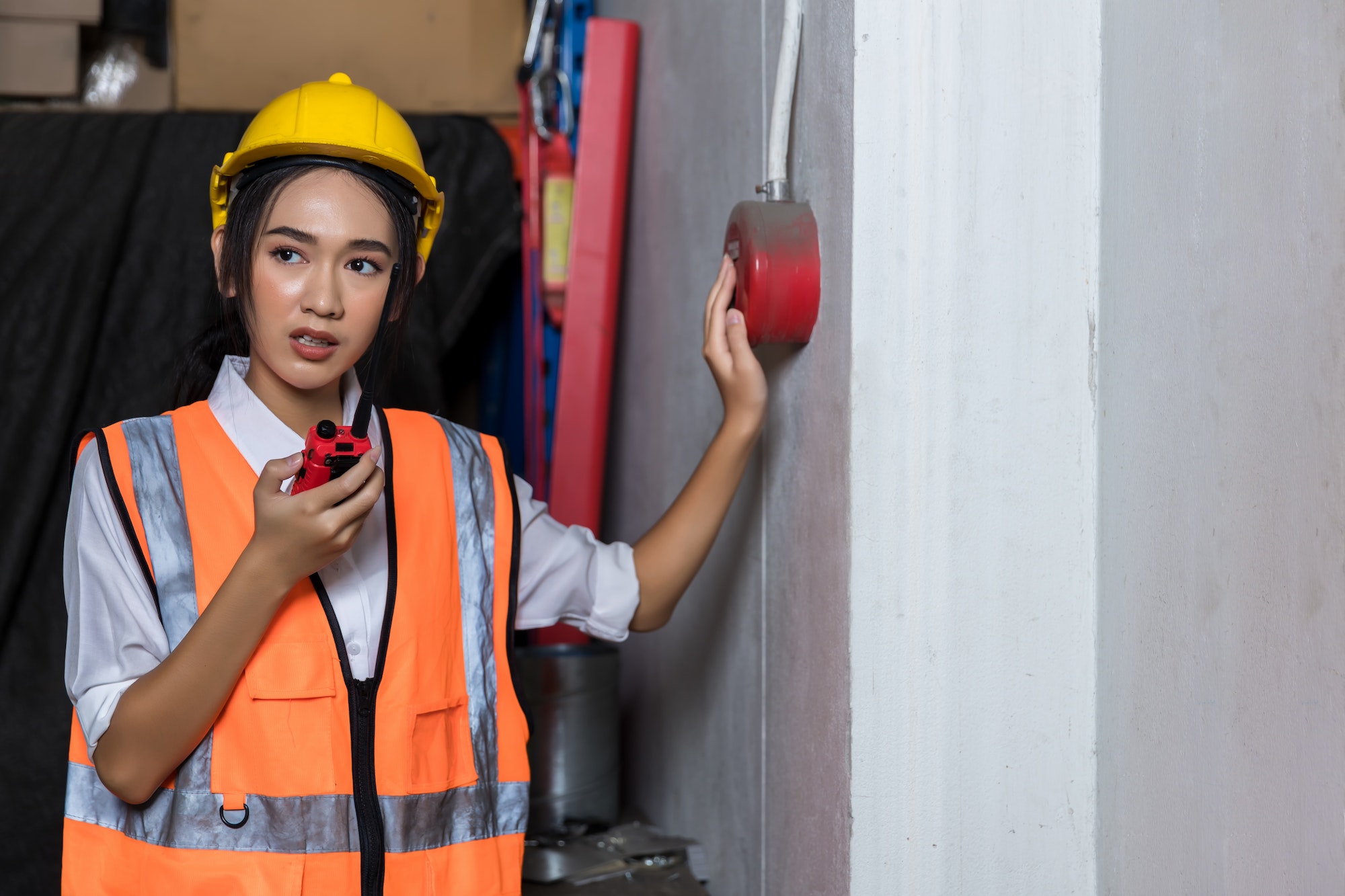 Foreman or worker pushing fire alarm on the wall. A fire! or Emergency case at the factory building.