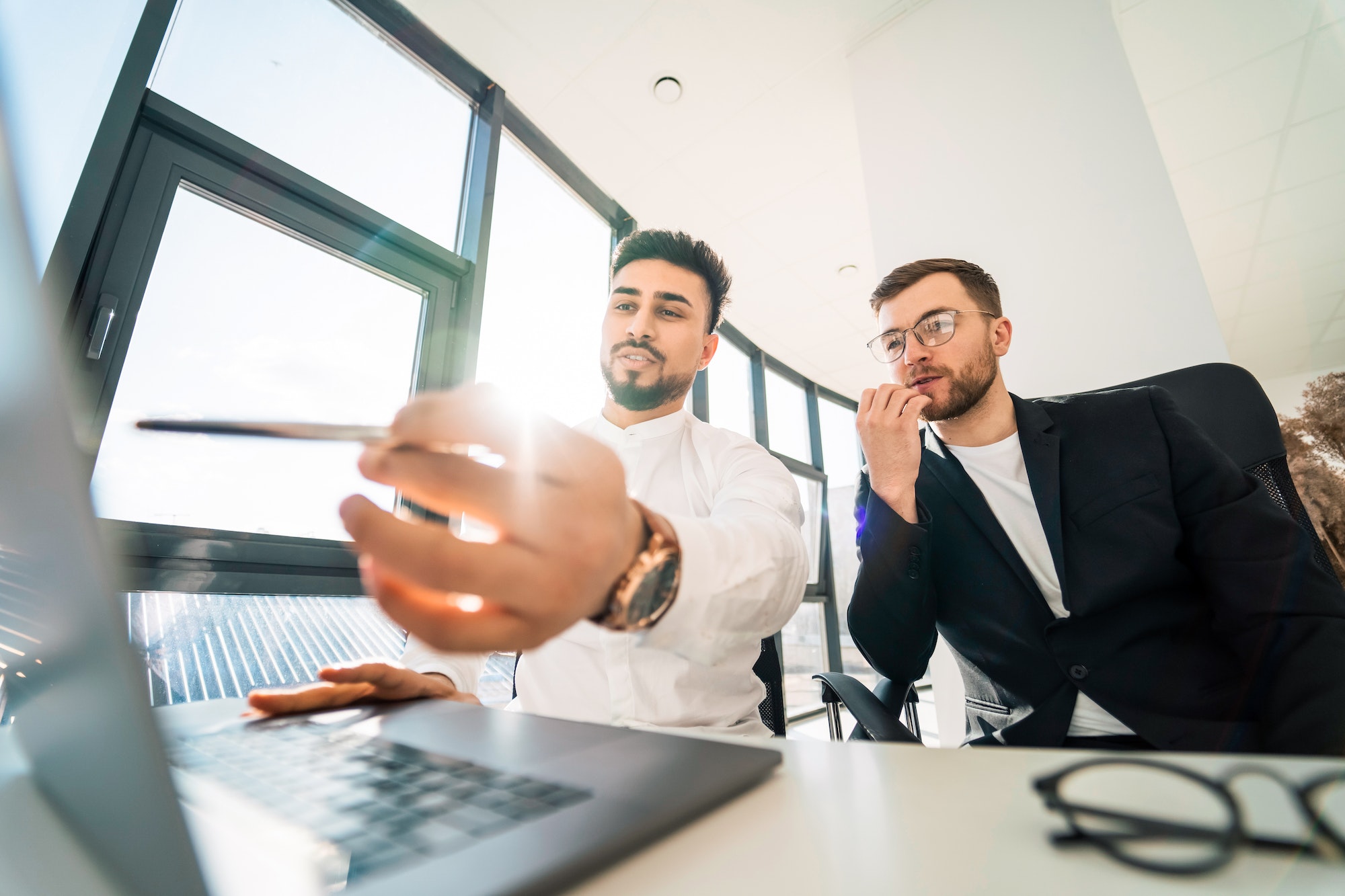 Two businessmen working on laptop on new project